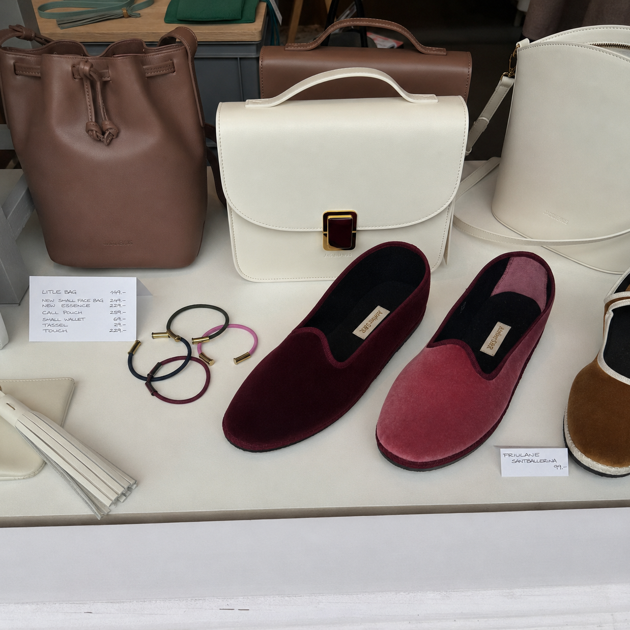Display of bracelets, handbags and shoes on a table with price tags. In a store in Zürich called Atelier S&R